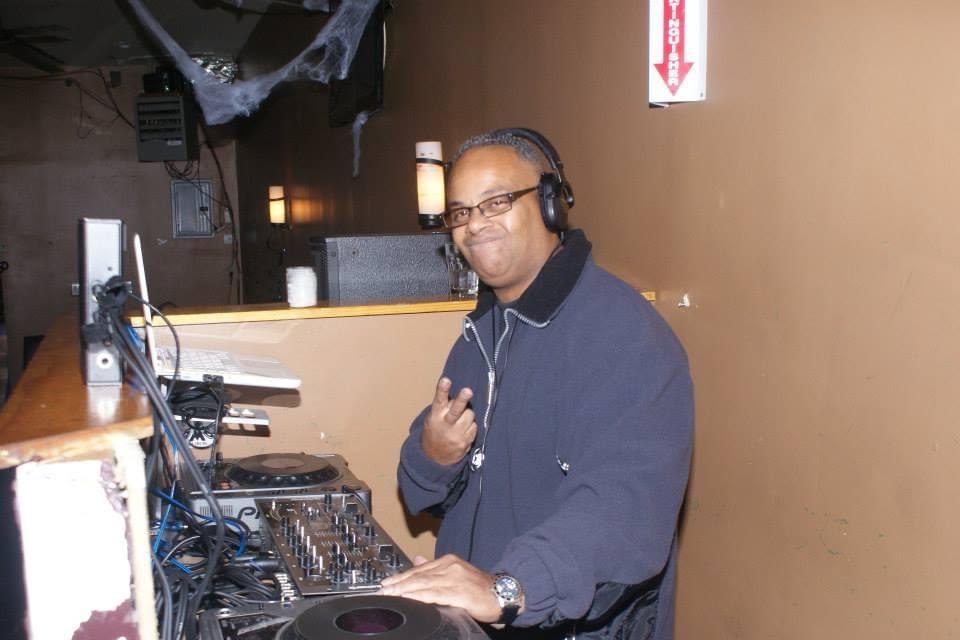 DJ Dr Arn Jay behind the decks with headphones